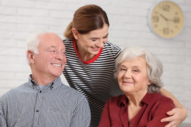 Elderly couple with female caregiver at home