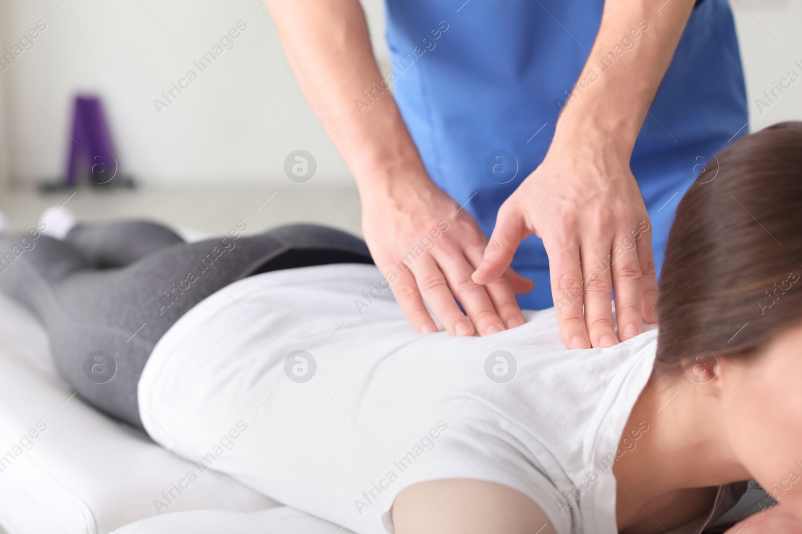 Photo of Physiotherapist working with female patient in clinic