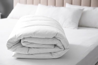 Photo of Soft folded blanket on bed at home