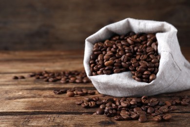 Photo of Bag of roasted coffee beans on wooden table, closeup. Space for text