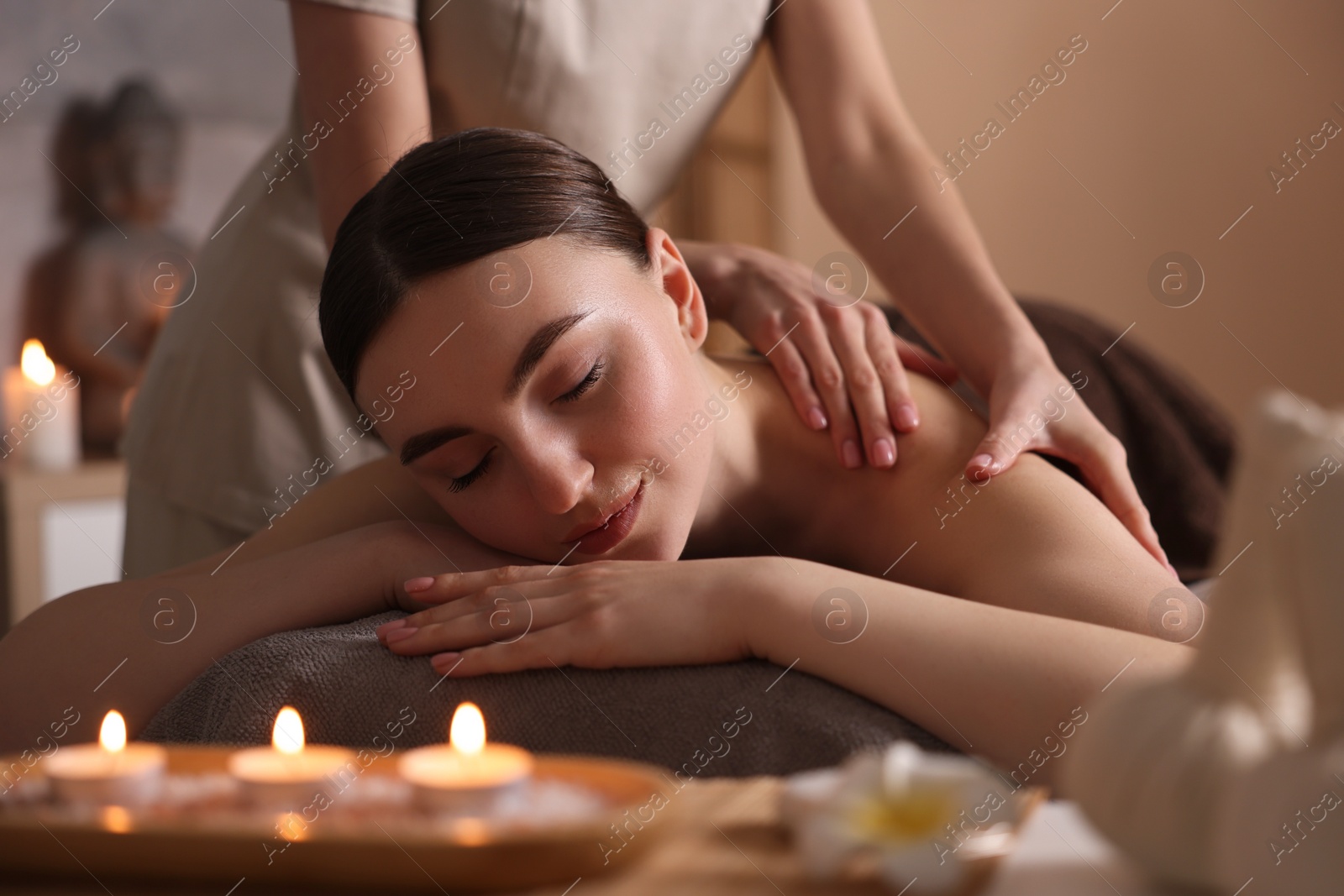 Photo of Spa therapy. Beautiful young woman lying on table during massage in salon