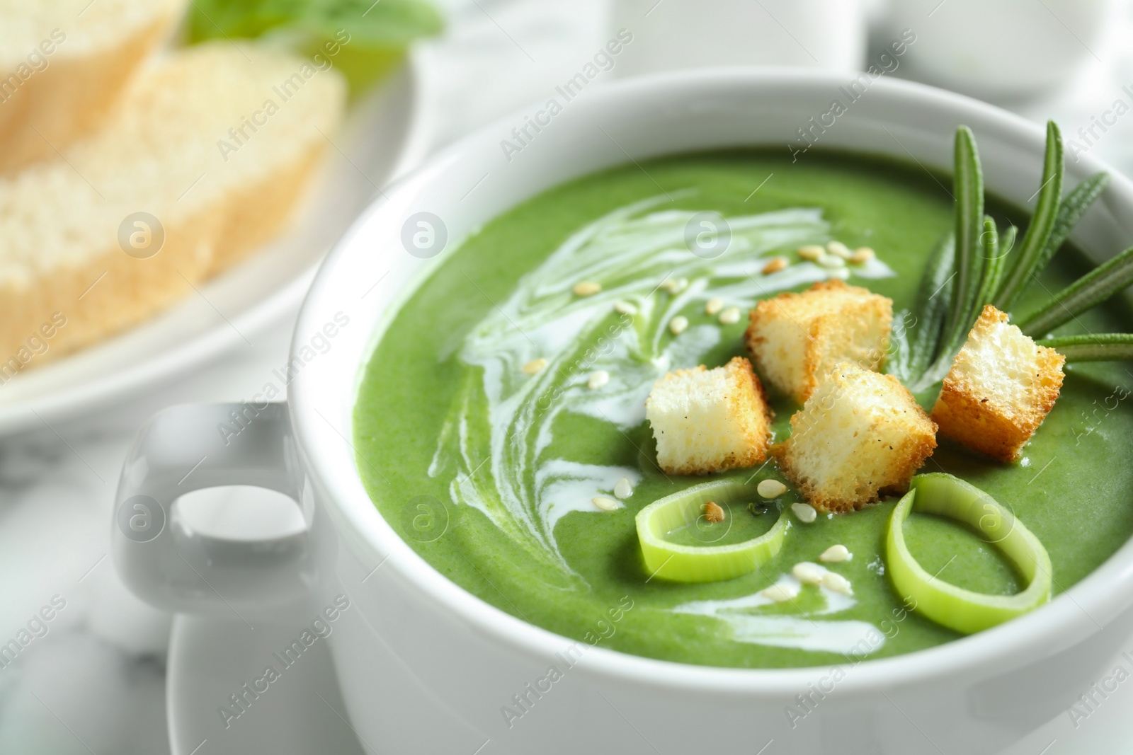 Photo of Fresh vegetable detox soup with croutons in dish on table, closeup