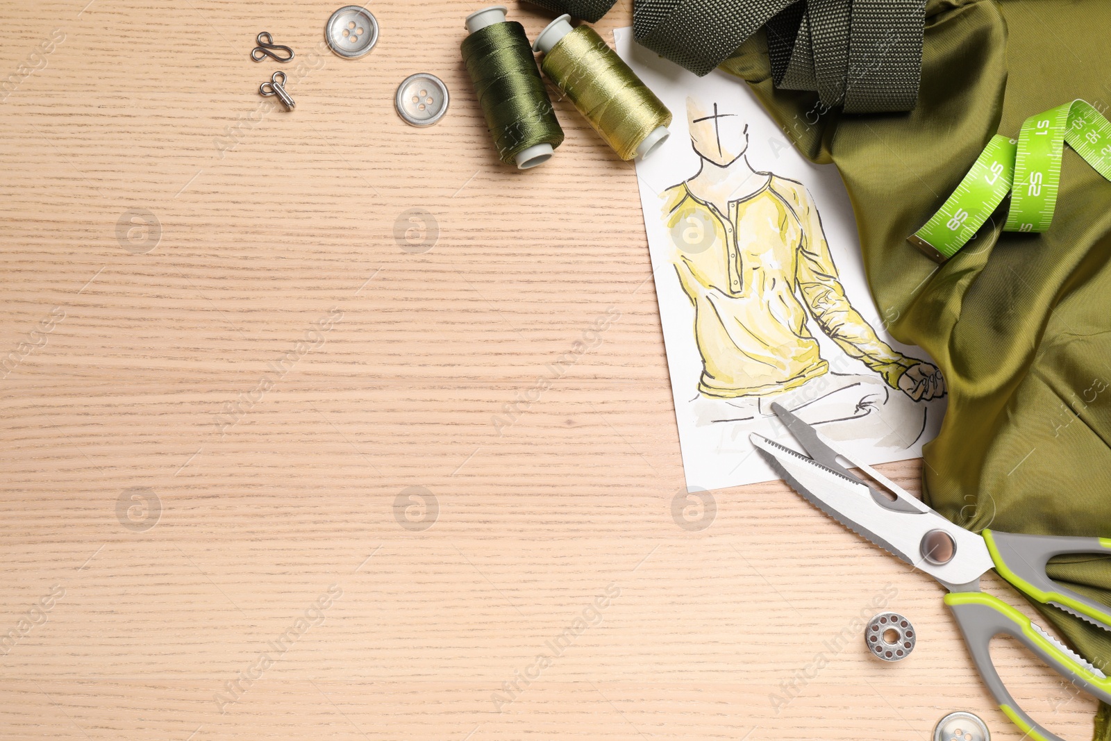 Photo of Flat lay composition with sketch and sewing accessories on wooden background. Space for text