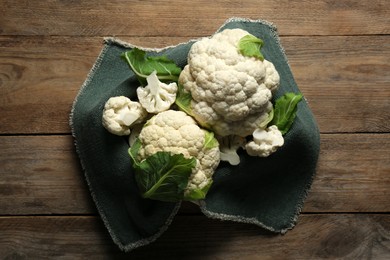Photo of Cut and whole cauliflowers on wooden table, top view