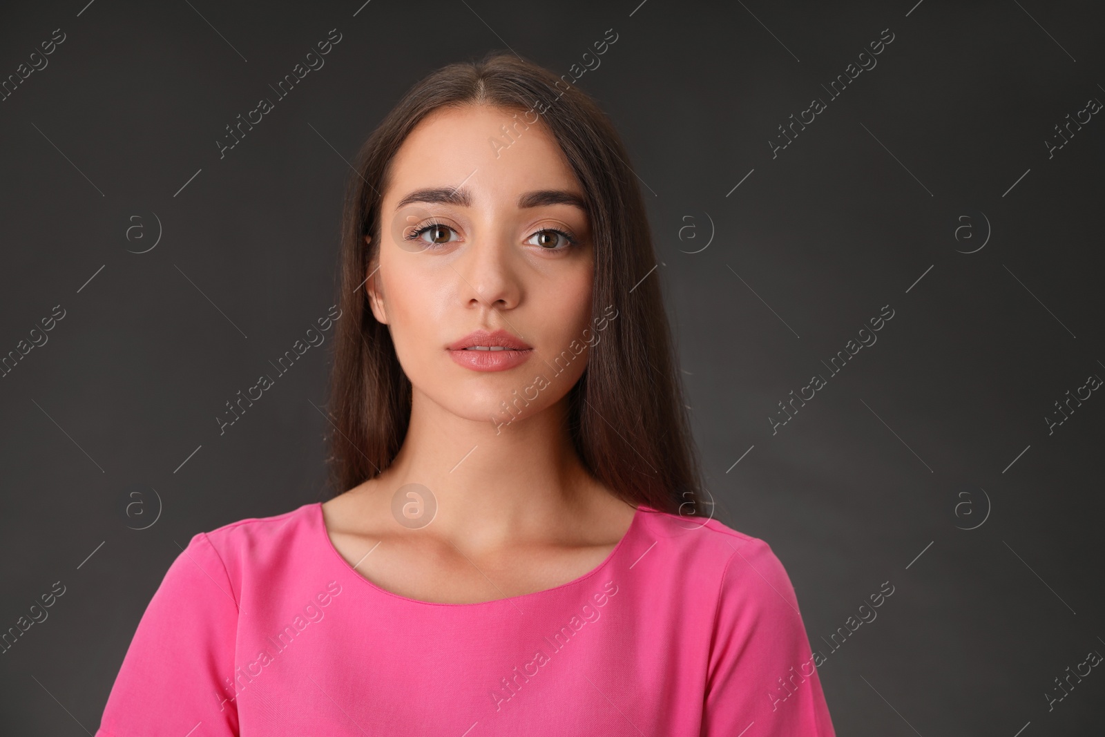 Photo of Portrait of beautiful young woman on dark grey background