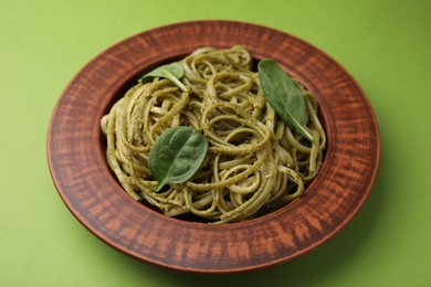 Photo of Tasty pasta with spinach on green table