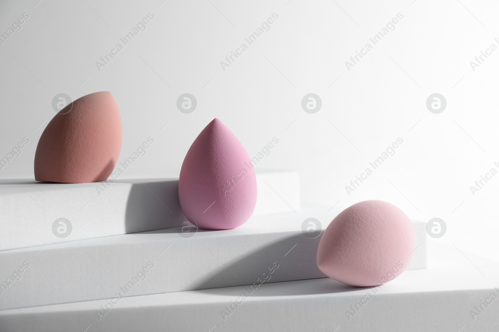 Photo of Stylish presentation of makeup sponges on white background