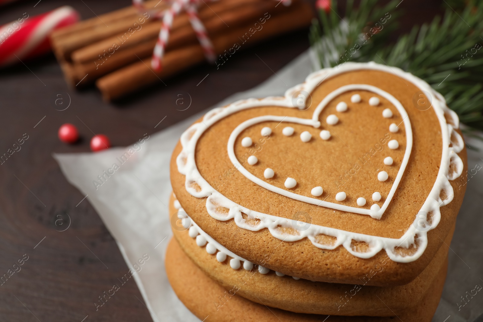 Photo of Tasty heart shaped gingerbread cookies on wooden table, closeup