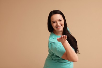 Photo of Beautiful overweight woman with charming smile on beige background. Space for text