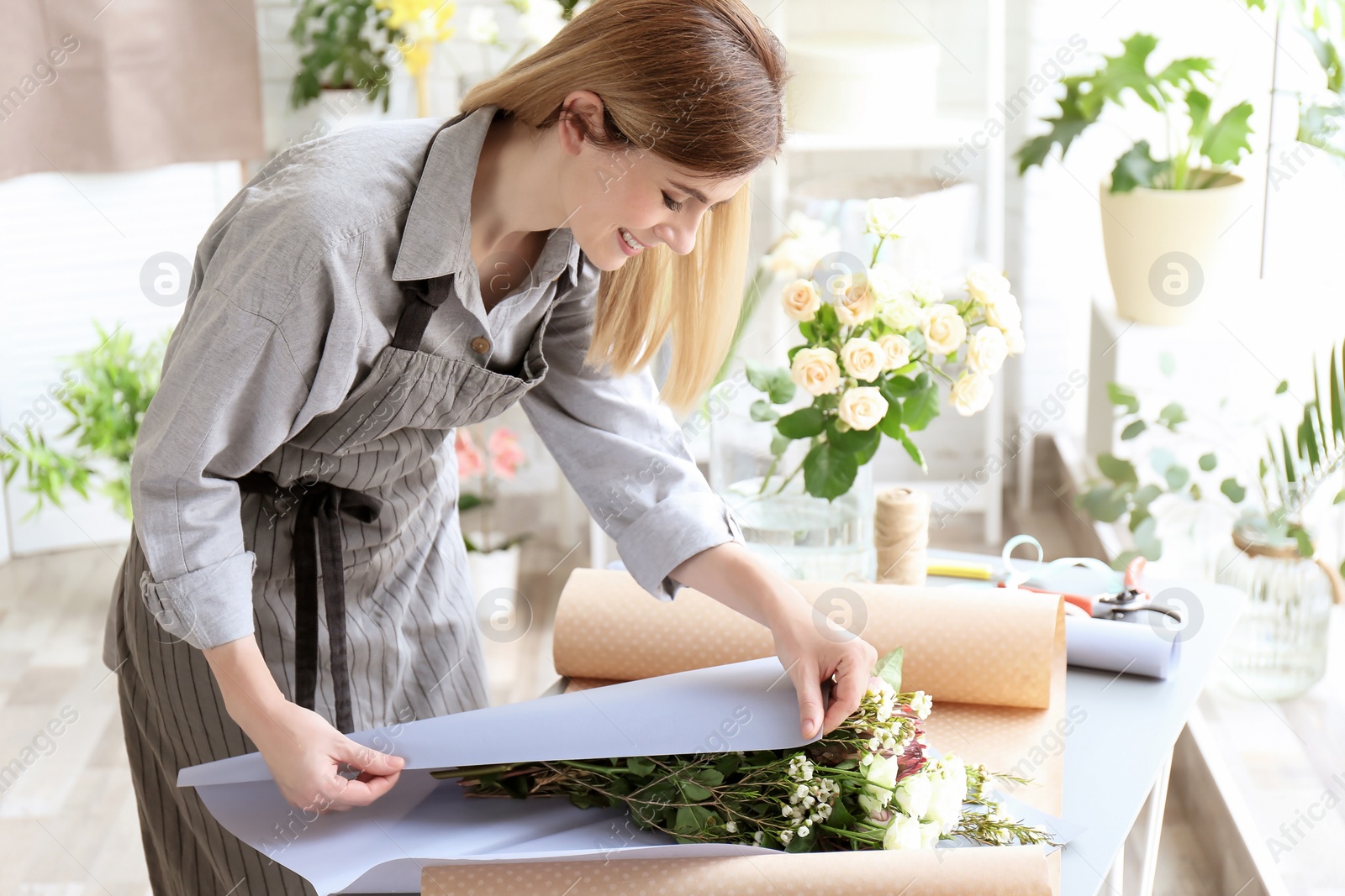 Photo of Female florist creating bouquet at workplace