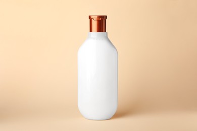 One bottle of shampoo on beige background