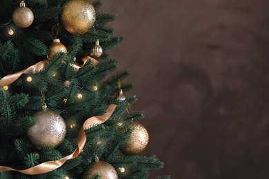 Beautiful Christmas tree with decor on brown background. Space for text