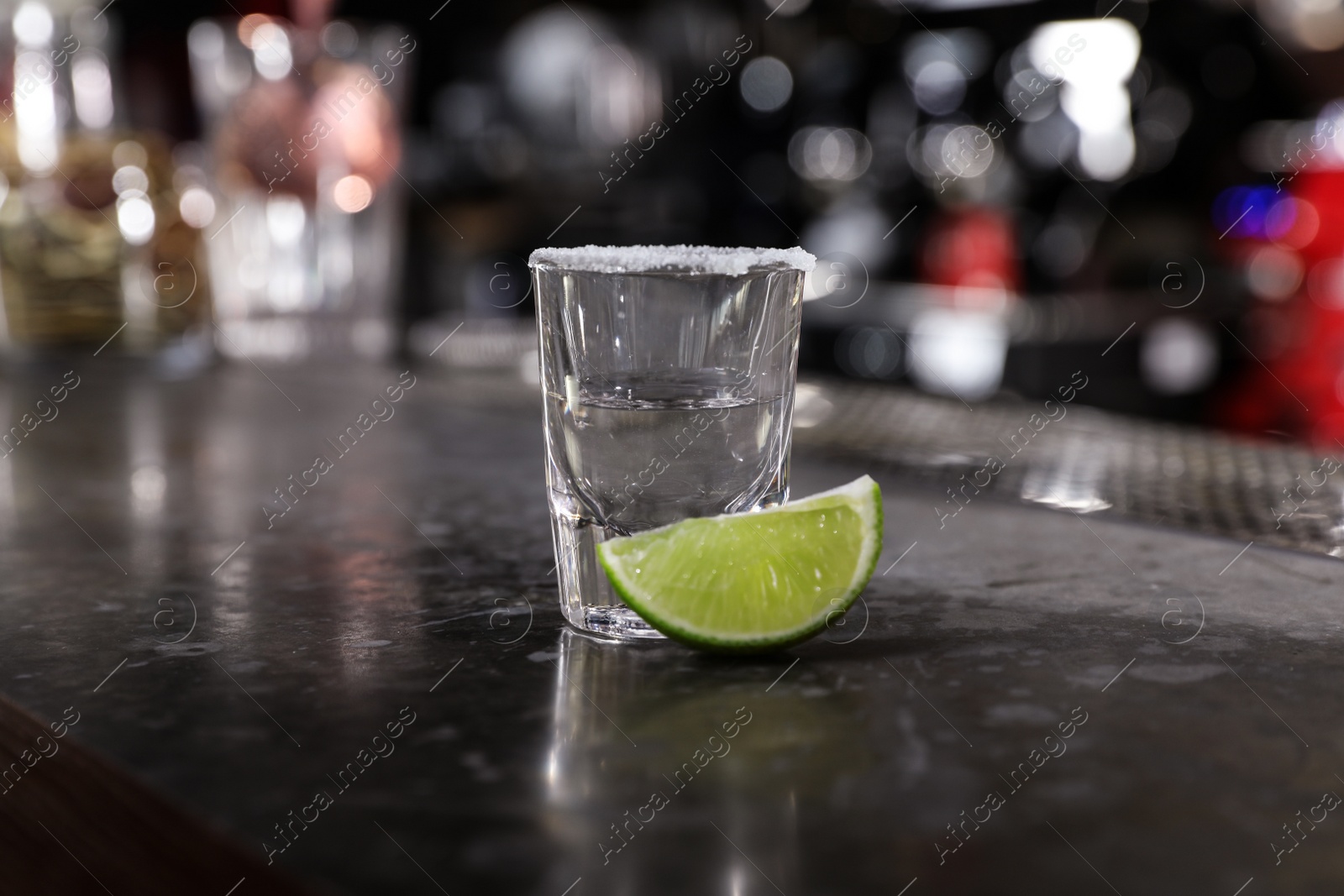 Photo of Mexican Tequila shot with lime slice on bar counter