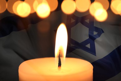 Image of Holocaust memory day. Double exposure of burning candle and flag of Israel