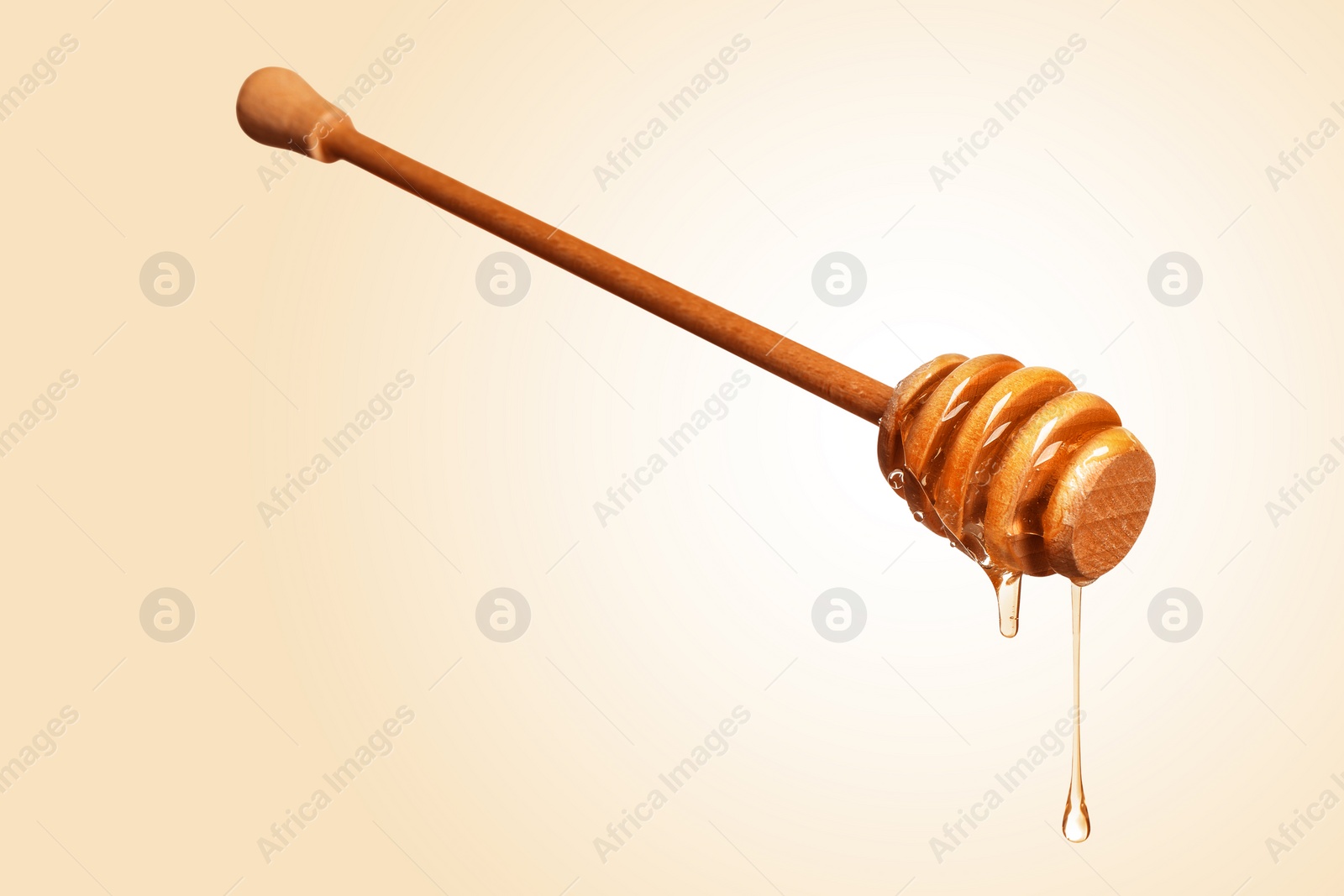 Image of Natural honey dripping from dipper on beige background