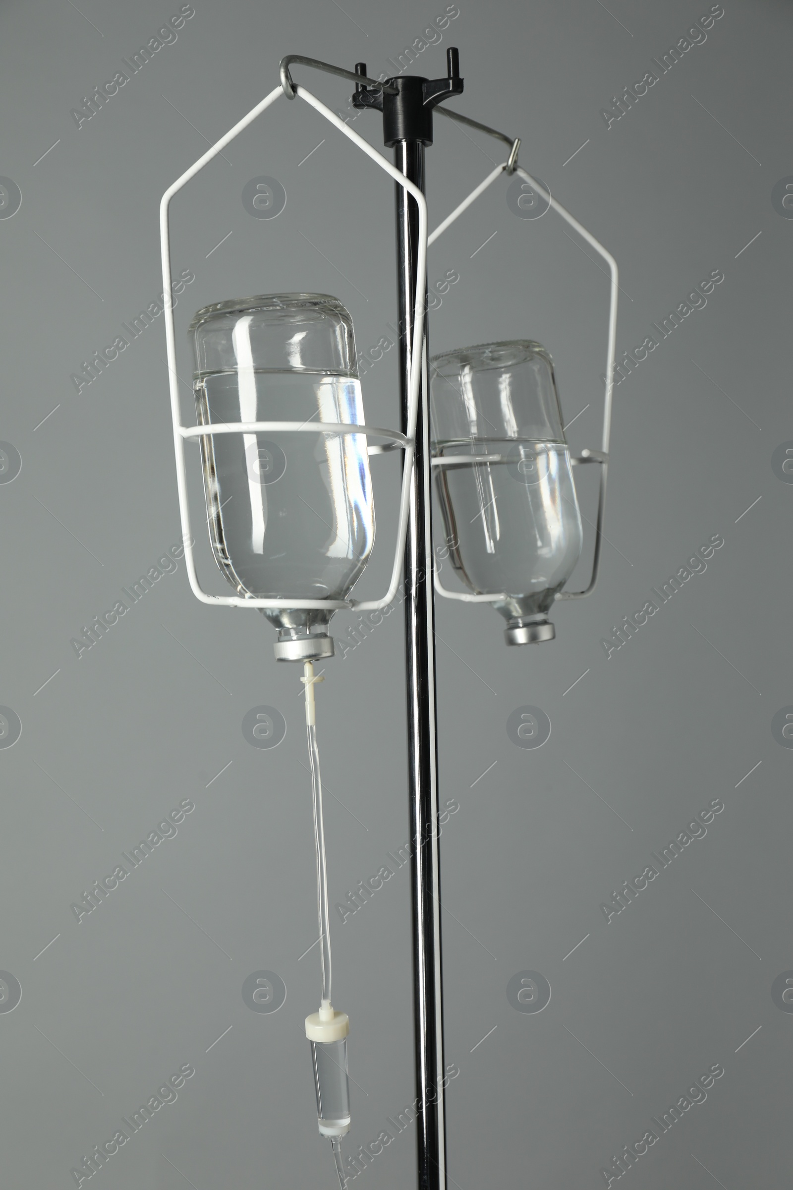 Photo of IV infusion set on pole against grey background