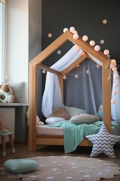 Stylish child room interior with house bed and different toys