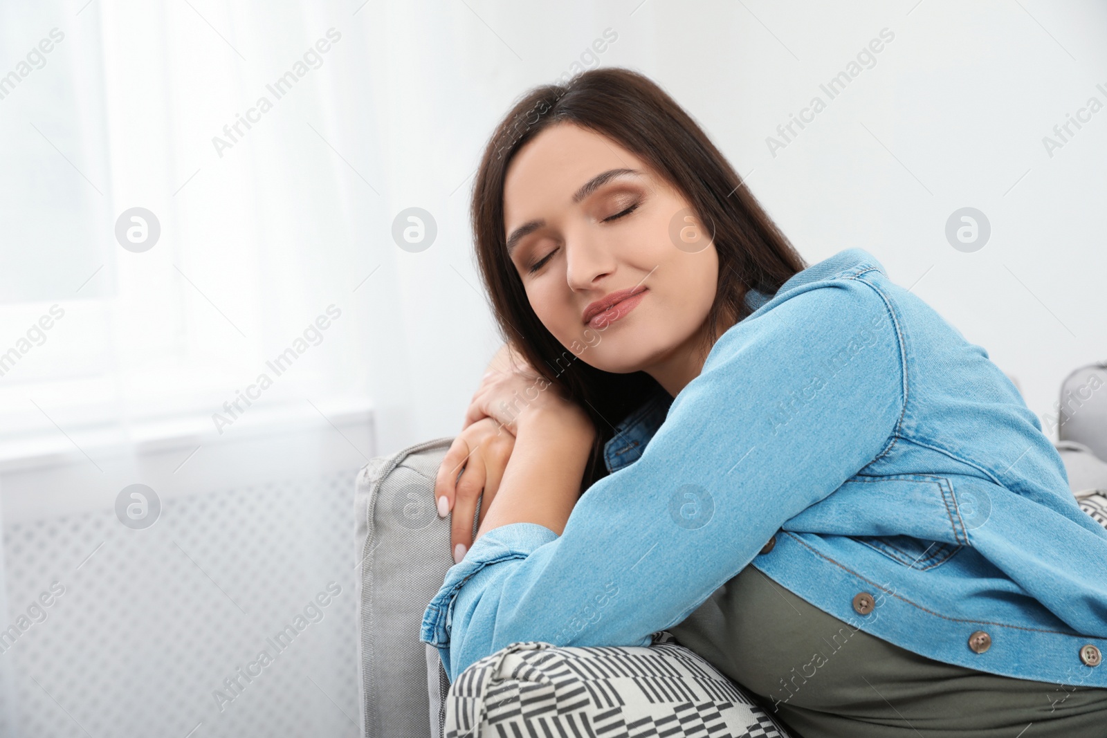 Photo of Young woman relaxing on couch at home