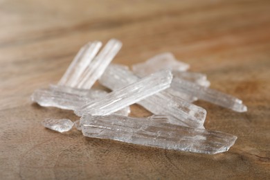 Menthol crystals on wooden background, closeup view