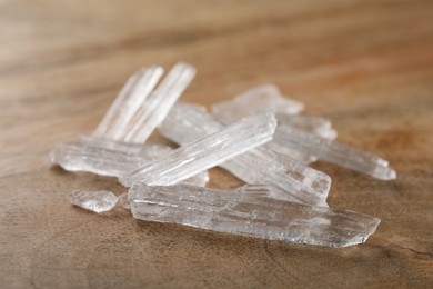 Photo of Menthol crystals on wooden background, closeup view