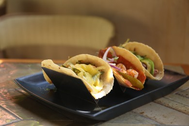 Photo of Delicious tacos with shrimps and vegetables on table