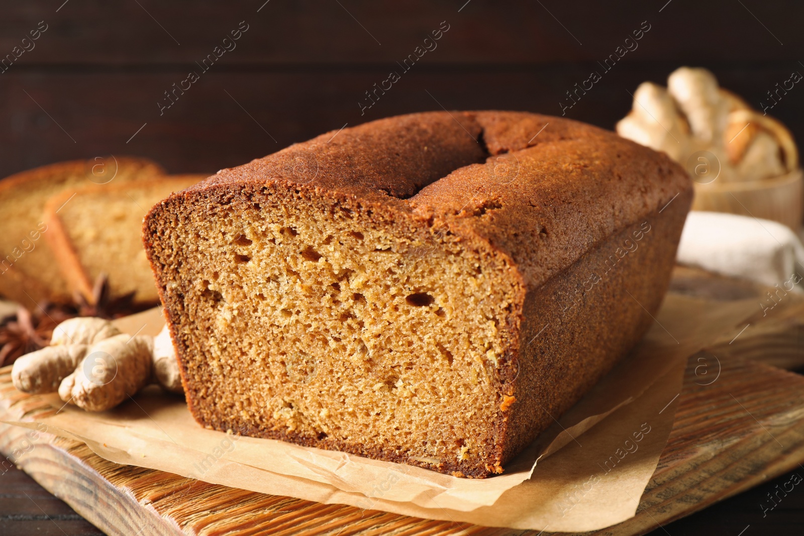 Photo of Delicious gingerbread cake on wooden board, closeup