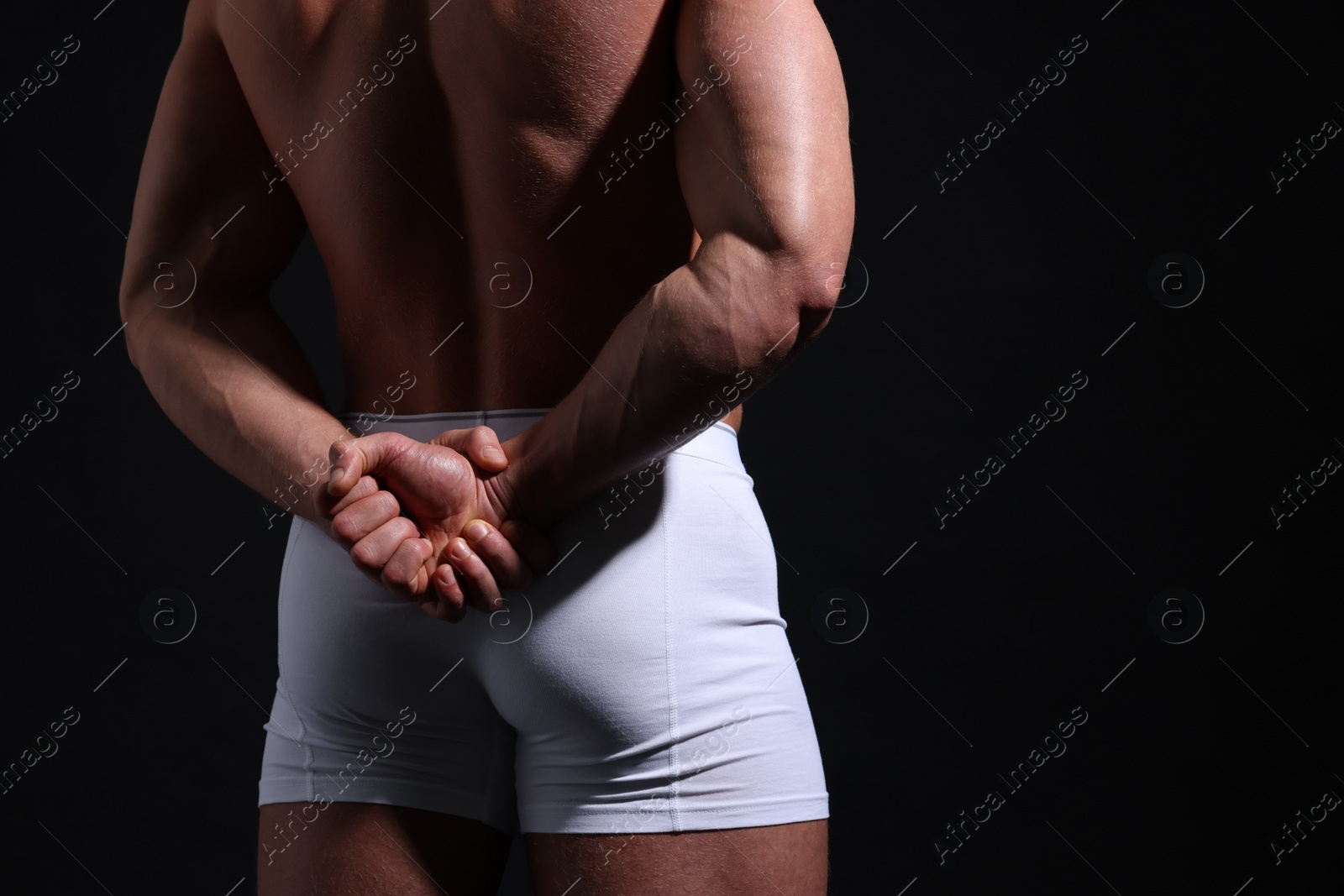 Photo of Young man in stylish white underwear on black background, closeup. Space for text