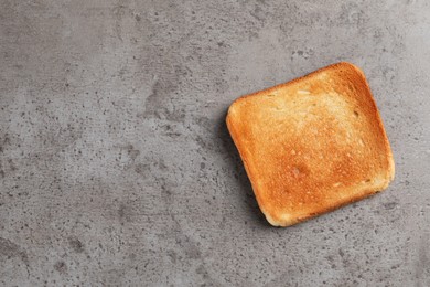 Photo of Slice of delicious toasted bread on gray table, top view. Space for text