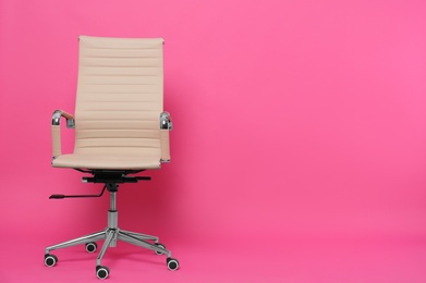 Photo of Comfortable office chair on pink background, space for text