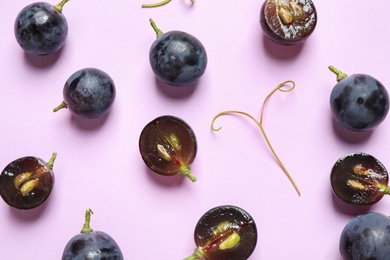 Photo of Flat lay composition with fresh ripe juicy grapes on lilac background