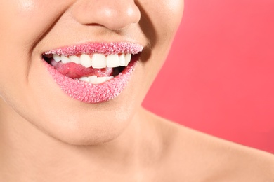 Beautiful young model with sugar lips on color background