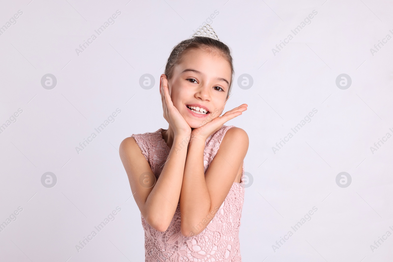 Photo of Cute girl in diadem on white background. Little princess