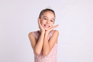 Cute girl in diadem on white background. Little princess
