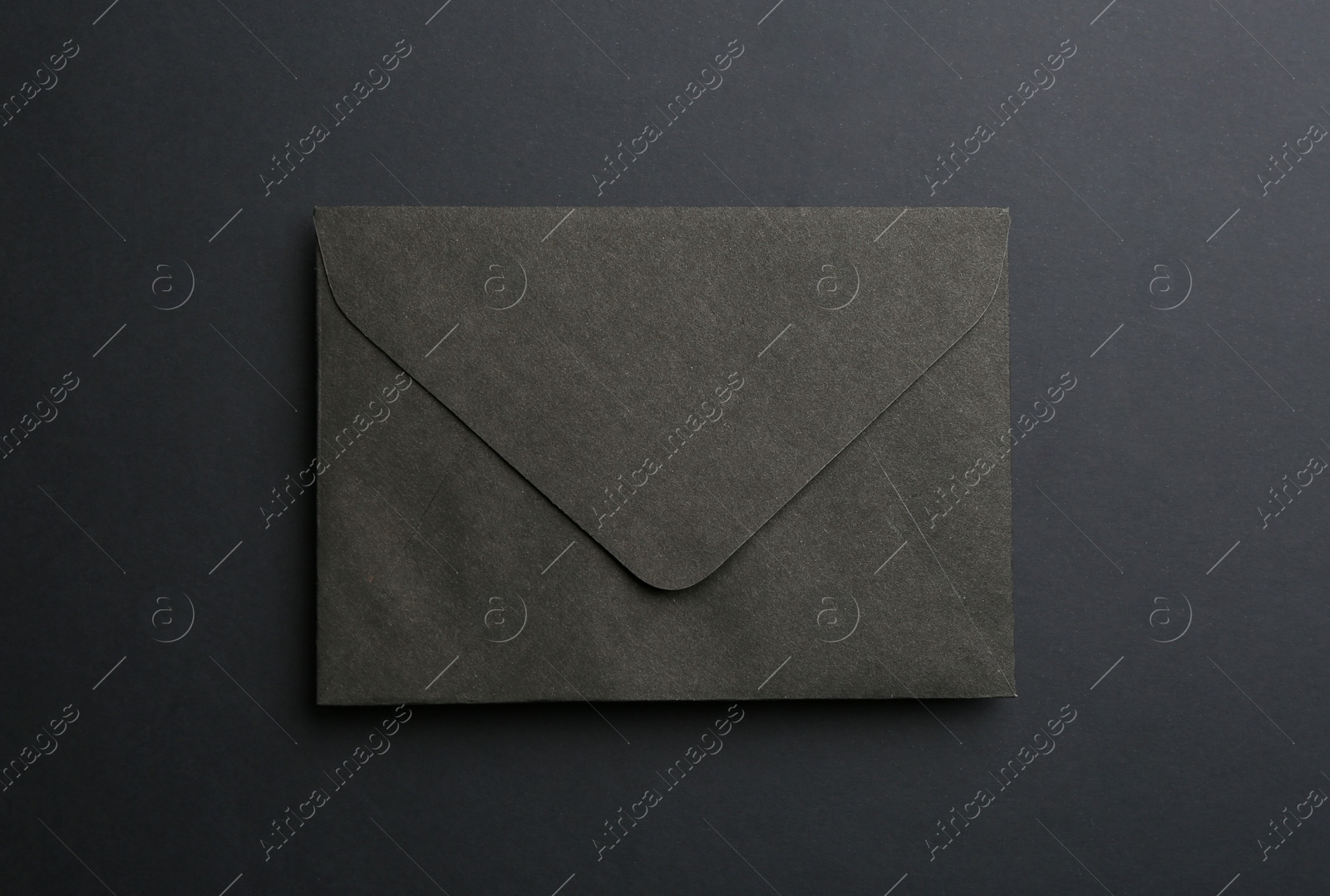 Photo of Paper envelope on black background, top view