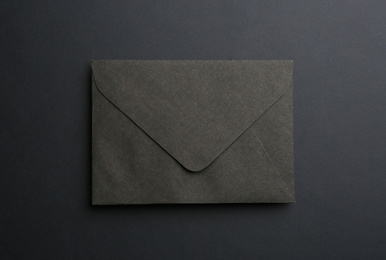 Paper envelope on black background, top view