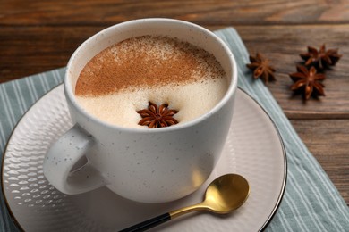 Photo of Cup of delicious eggnog with anise on wooden table