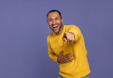Photo of Portrait of laughing African American man on purple background. Space for text
