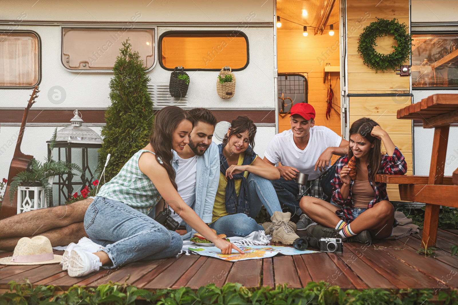 Photo of Young travelers with world map planning trip near motorhome