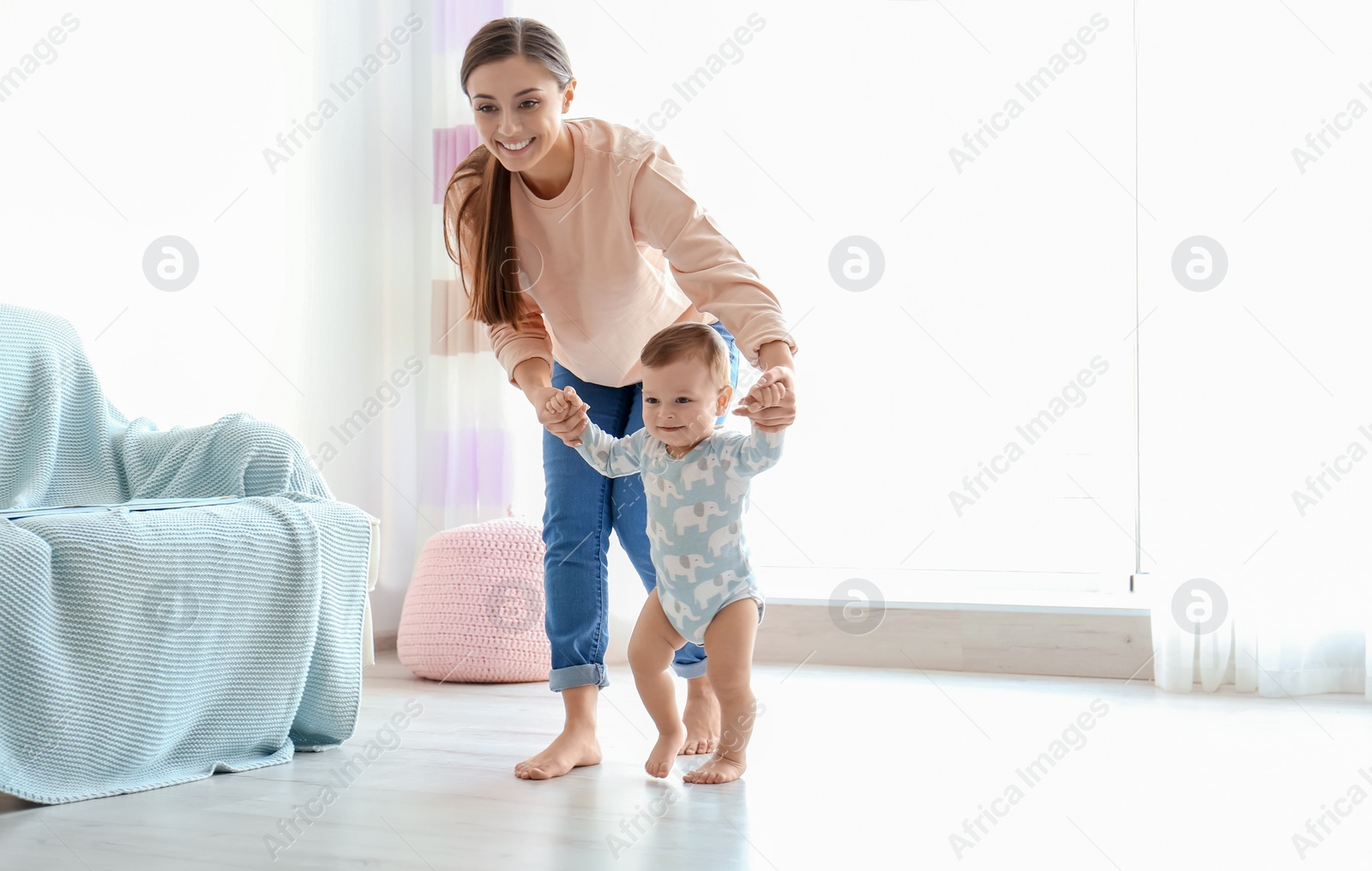 Photo of Baby taking first steps with mother's help at home