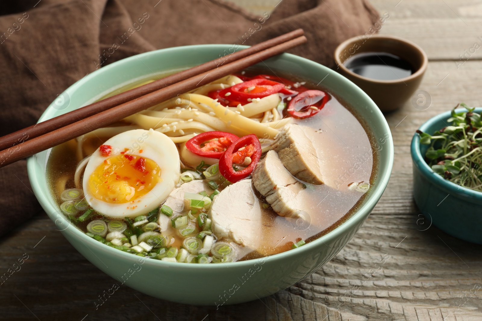 Photo of Delicious ramen in bowl on wooden table, closeup. Noodle soup