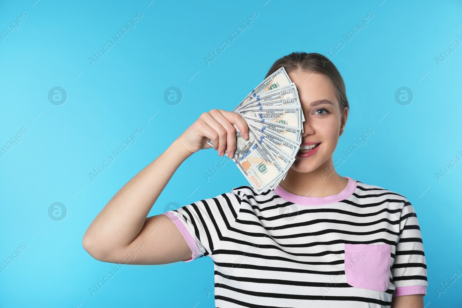 Photo of Portrait of happy young woman with money on color background. Space for text