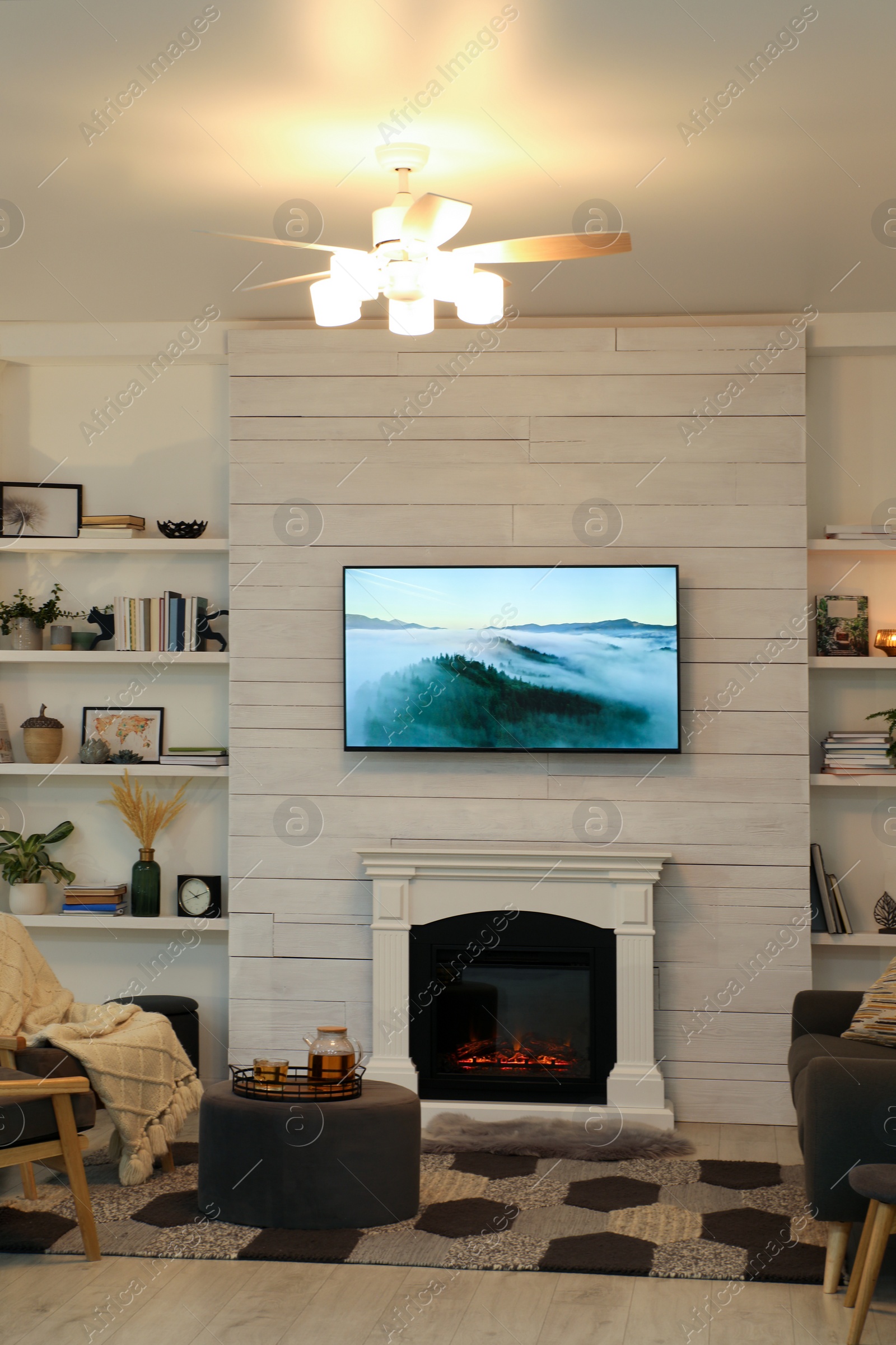 Photo of Cozy living room interior with comfortable sofa, armchairs and decorative fireplace