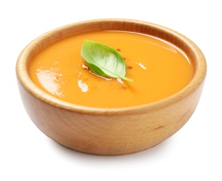 Tasty creamy pumpkin soup with basil in bowl on white background