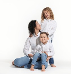 Photo of Little children with their mother on white background