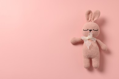 Photo of Baby accessory. Toy rabbit on pink background, top view. Space for text