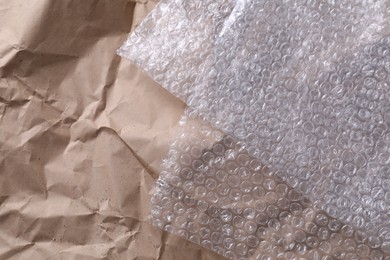 Photo of Transparent bubble wrap on kraft paper, top view. Space for text