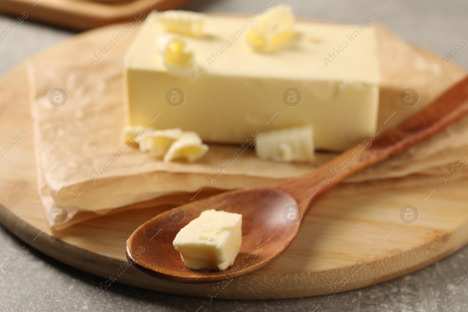 Photo of Block of tasty butter on grey table, closeup