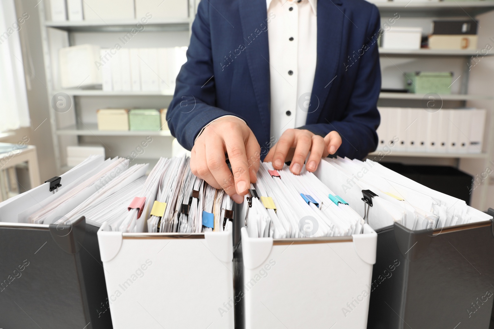 Photo of Woman taking documents from folder in archive, closeup