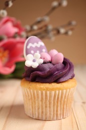 Tasty cupcake with Easter decor on wooden table