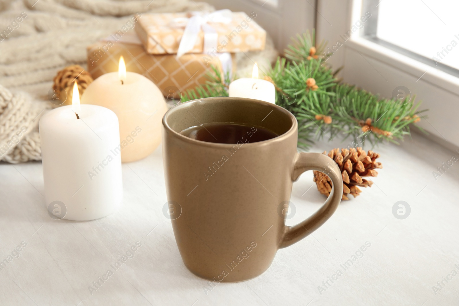 Photo of Composition with cup of hot winter drink near window. Cozy season